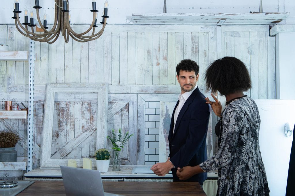 In a modern clothes fashion room a clothing designer or tailor allows buyers to try on model